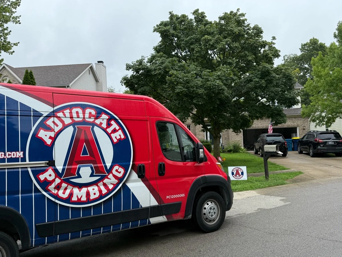Advocate Plumbing service van parked outside a home on a residential street